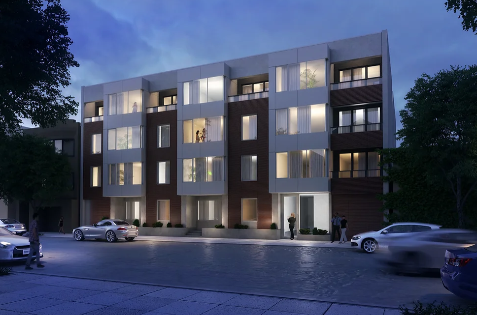 A night time view of a building with cars parked in front of it